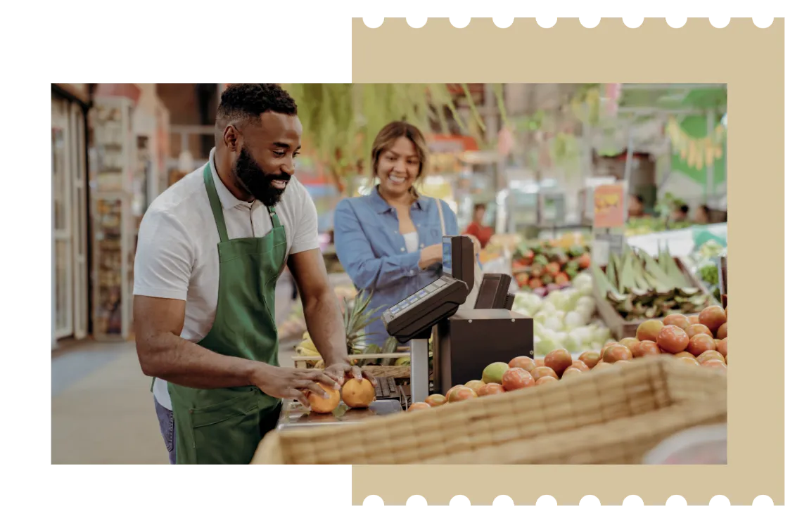 Shop assistant weighing fresh produce on integrated scales at a market counter