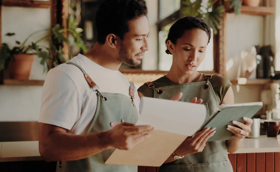 Two shop owners reviewing figures on a laptop