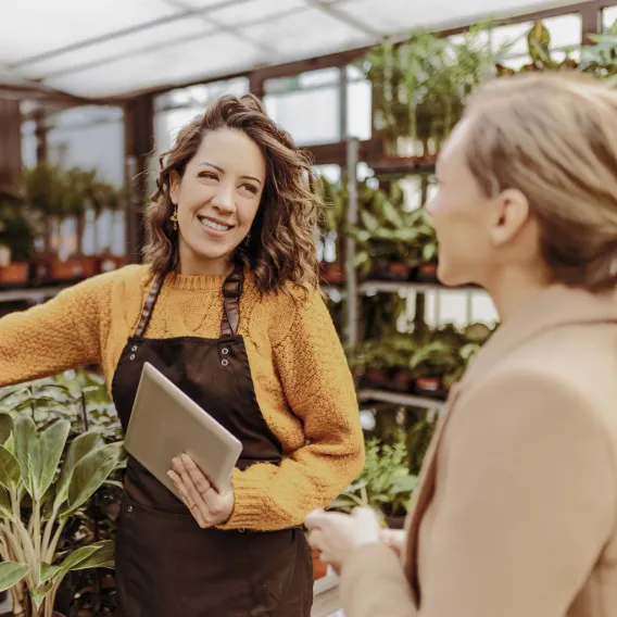 Garden centre colleague with a tablet talking to a customer